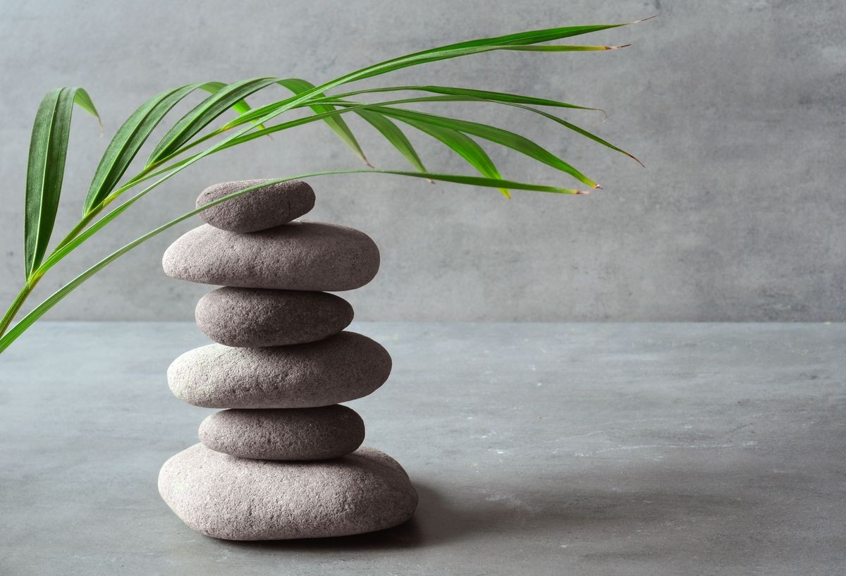 Stones and green palm leaf balance. Zen and spa concept.