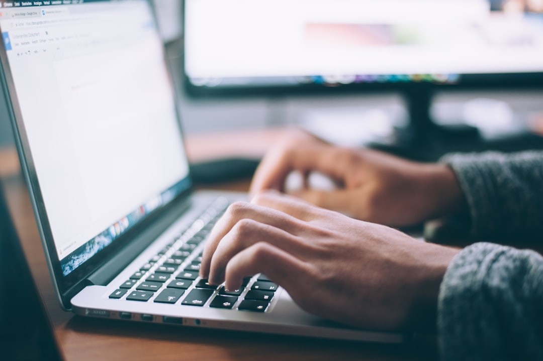 person typing on a laptop, video conferencing